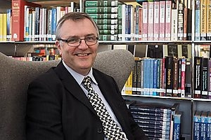 A photograph of librarian, Timothy, smiling at the camera